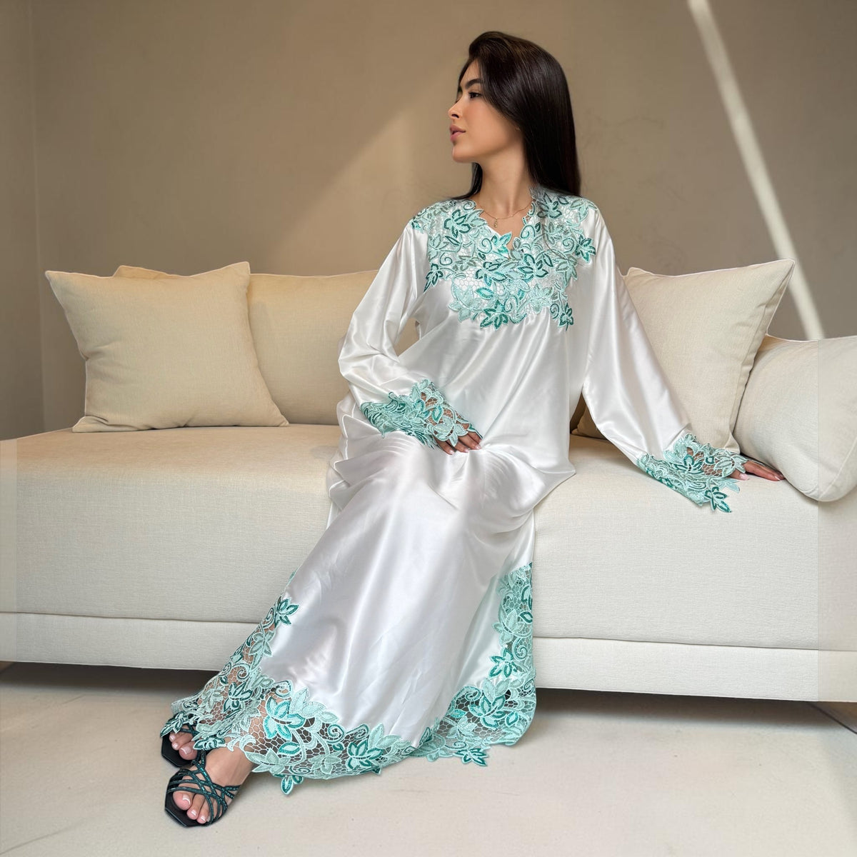 ABAYAS white Nida lace dress with emerald and turquoise floral embroidery on neckline, sleeves, and hem. Long sleeves, V-neck.